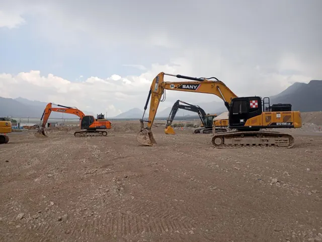 Excavadoras trabajando en obra con montañas de Nuevo León al fondo