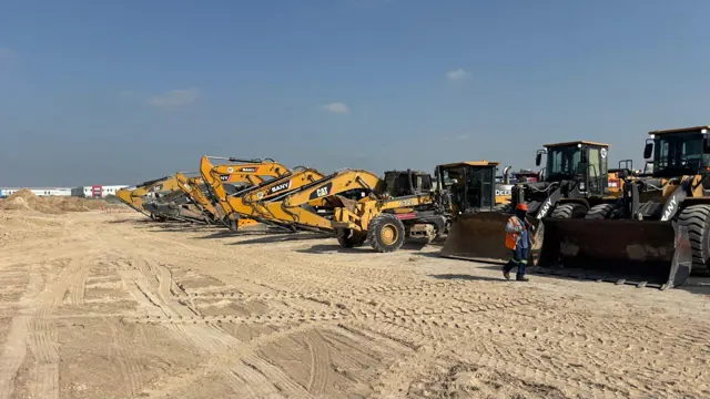 Flotilla de excavadoras, motoniveladora y cargadores frontales de MCM en obra